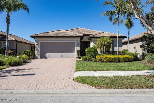 view of front of property featuring stucco siding, decorative driveway, a garage, and a tile roof