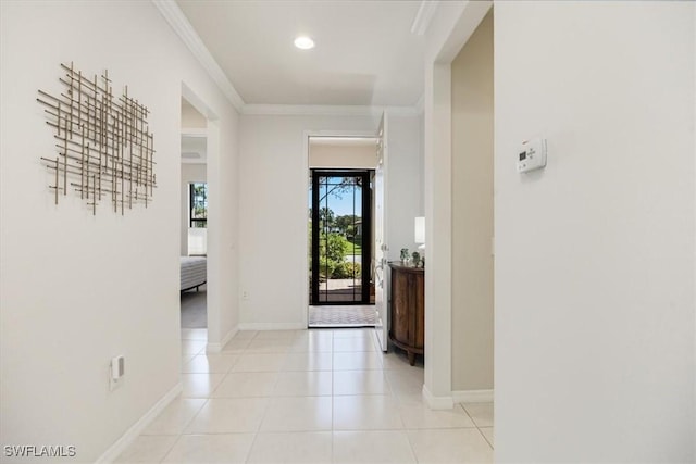 hall featuring light tile patterned floors, baseboards, and ornamental molding