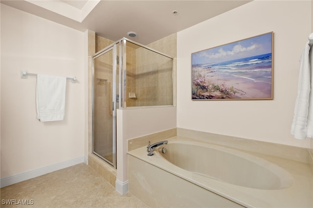 bathroom featuring a garden tub, baseboards, a shower stall, and tile patterned floors