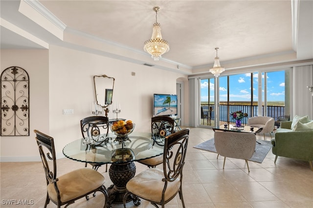 dining room with crown molding, a tray ceiling, light tile patterned floors, and an inviting chandelier