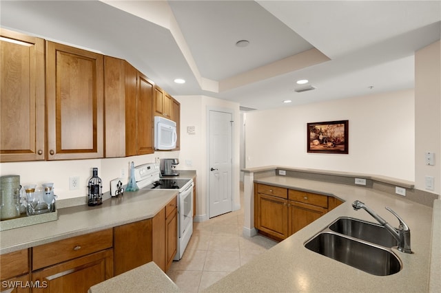 kitchen with light tile patterned floors, white appliances, a sink, visible vents, and brown cabinetry