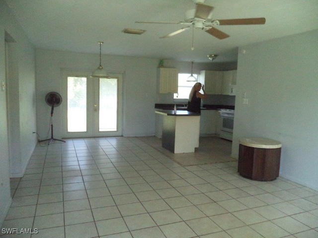 kitchen with light tile patterned floors, white cabinets, open floor plan, french doors, and white range with electric cooktop