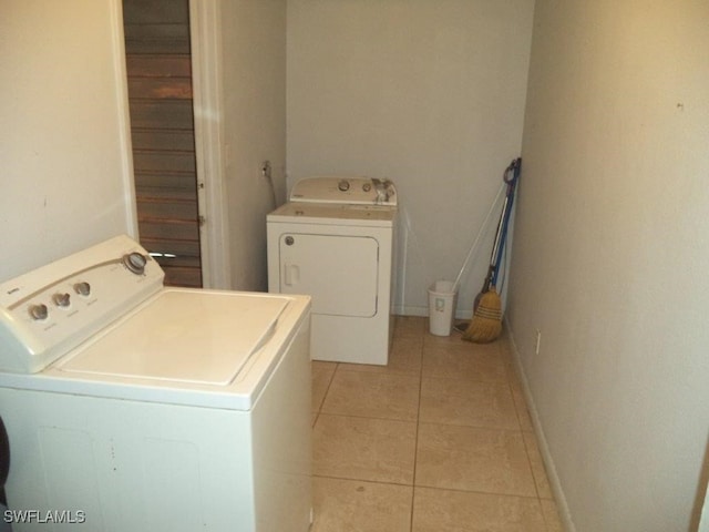 laundry area with laundry area, baseboards, separate washer and dryer, and light tile patterned flooring