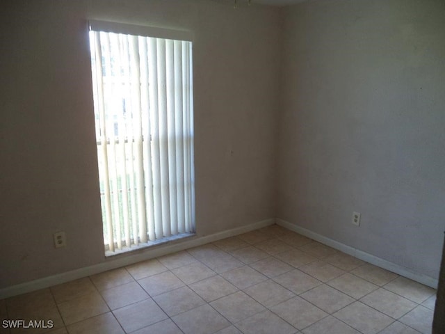 unfurnished room featuring baseboards and light tile patterned floors