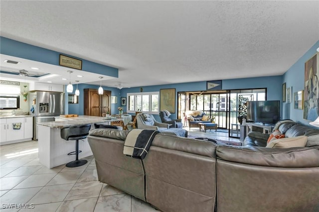 living room featuring a textured ceiling, light tile patterned floors, and recessed lighting