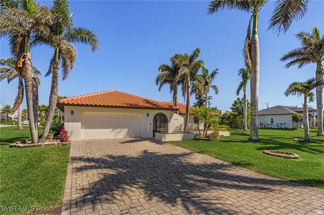 5305 SW 25th Ct, Cape Coral, FL 33914 - mediterranean / spanish-style home featuring stucco siding, an attached garage, a front lawn, a tile roof, and decorative driveway
