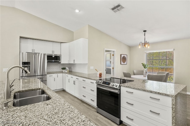 kitchen with visible vents, a sink, stainless steel appliances, a peninsula, and vaulted ceiling