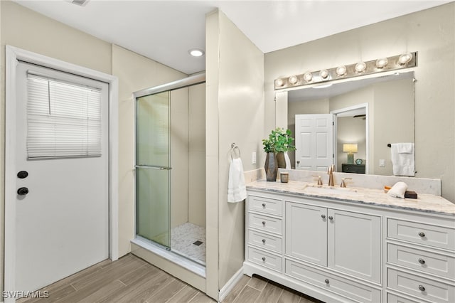 ensuite bathroom with vanity, ensuite bath, a stall shower, and wood tiled floor