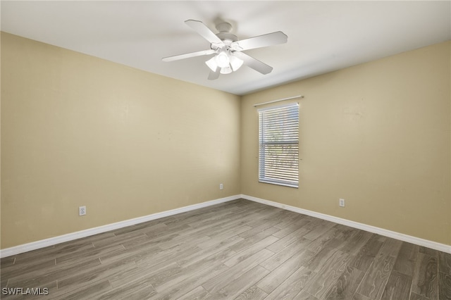 unfurnished room with ceiling fan, baseboards, and wood finished floors