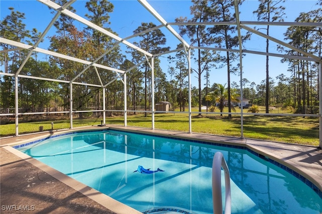 outdoor pool featuring glass enclosure, an outbuilding, a patio, a storage shed, and a lawn