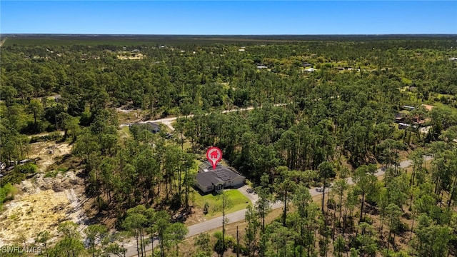 bird's eye view with a wooded view