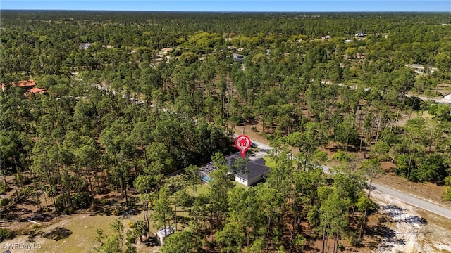 drone / aerial view with a wooded view