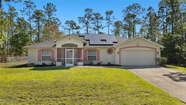 ranch-style house featuring a front yard, solar panels, an attached garage, stucco siding, and concrete driveway