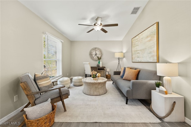 living room featuring visible vents, baseboards, wood finished floors, and a ceiling fan