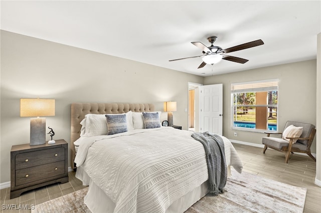 bedroom featuring ceiling fan, baseboards, and wood finish floors