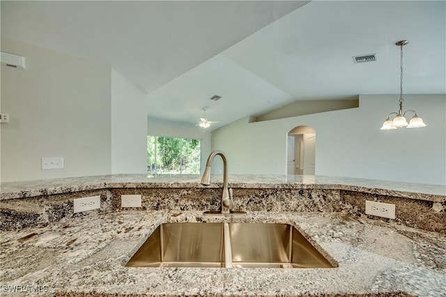 interior details with visible vents, light stone counters, a sink, and pendant lighting