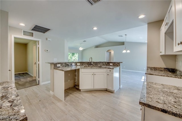 kitchen with a sink, visible vents, and white cabinets