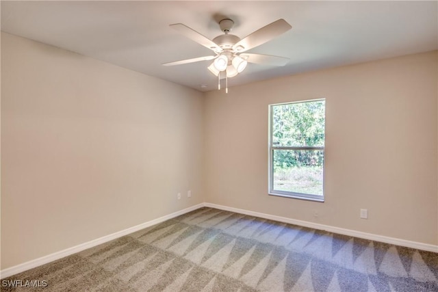 empty room with carpet floors, a ceiling fan, and baseboards