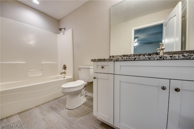 full bath featuring bathtub / shower combination, vanity, and toilet