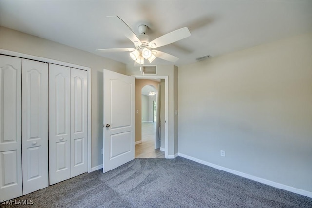 unfurnished bedroom featuring carpet floors, a closet, visible vents, and baseboards