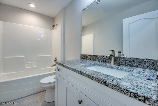 bathroom with toilet, shower / bath combination, wood finished floors, and vanity