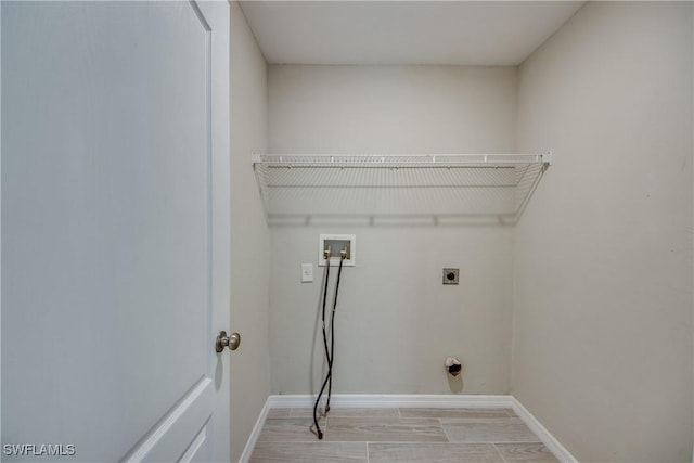 clothes washing area with laundry area, hookup for a washing machine, baseboards, and electric dryer hookup