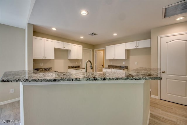 kitchen featuring white cabinetry, stone countertops, and visible vents