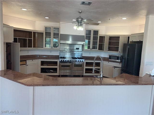 kitchen featuring visible vents, dark stone counters, stainless steel appliances, open shelves, and exhaust hood