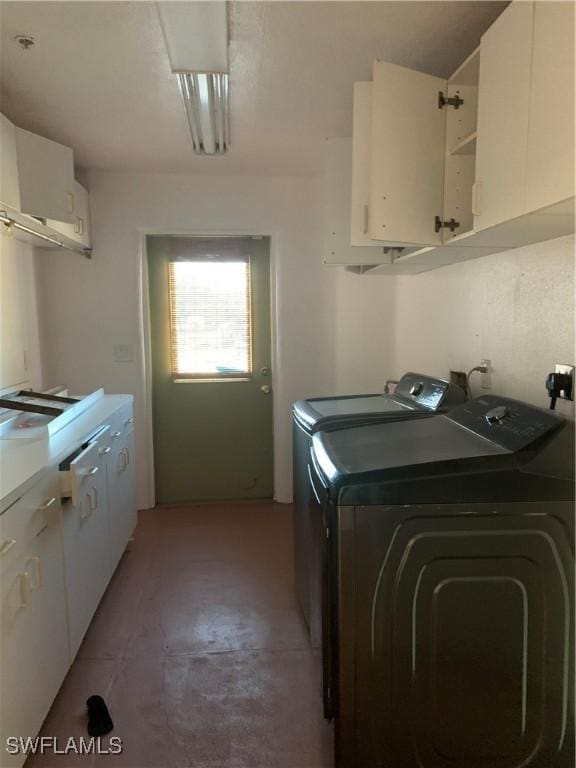 washroom with cabinet space and washing machine and dryer