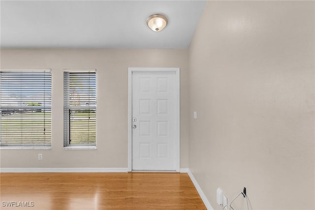 foyer entrance with light wood finished floors and baseboards