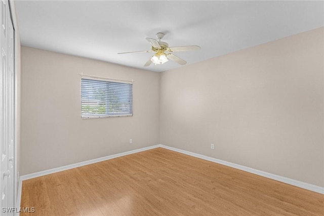 empty room featuring ceiling fan, baseboards, and wood finished floors