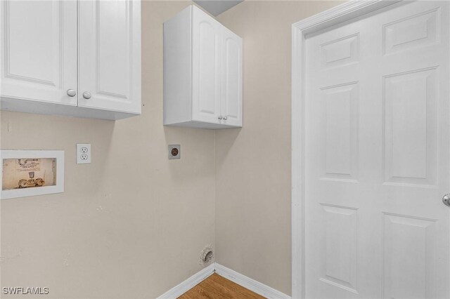 laundry area featuring hookup for a washing machine, hookup for an electric dryer, wood finished floors, baseboards, and cabinet space