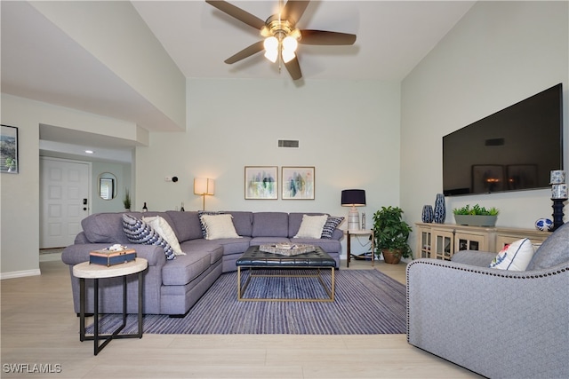 living room with baseboards, wood finished floors, visible vents, and a ceiling fan