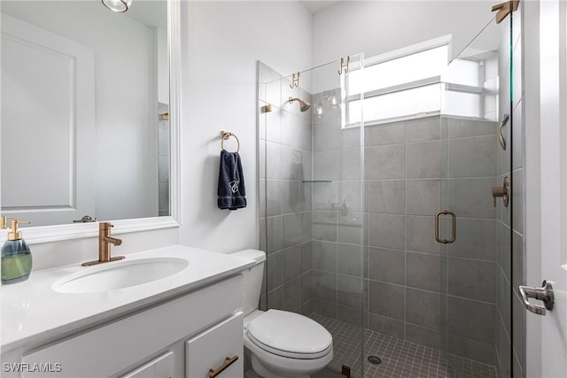 bathroom with toilet, a shower stall, and vanity