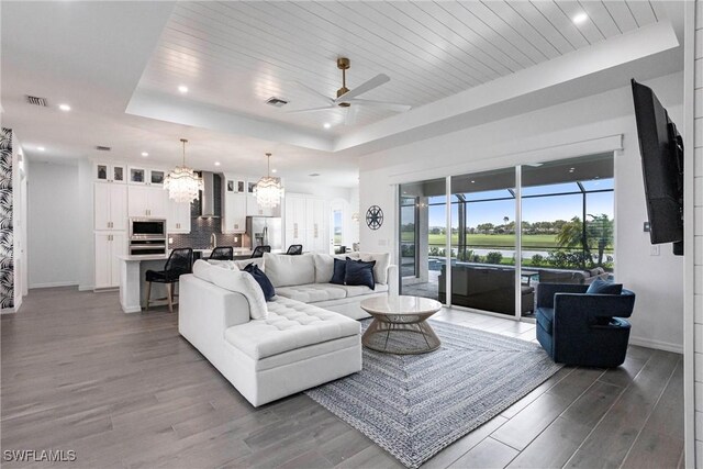 living area featuring light wood-type flooring, a raised ceiling, and wooden ceiling