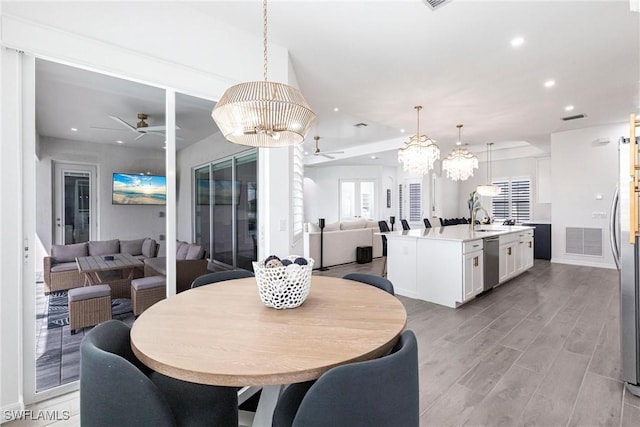 dining room with ceiling fan with notable chandelier, recessed lighting, visible vents, and light wood-style floors