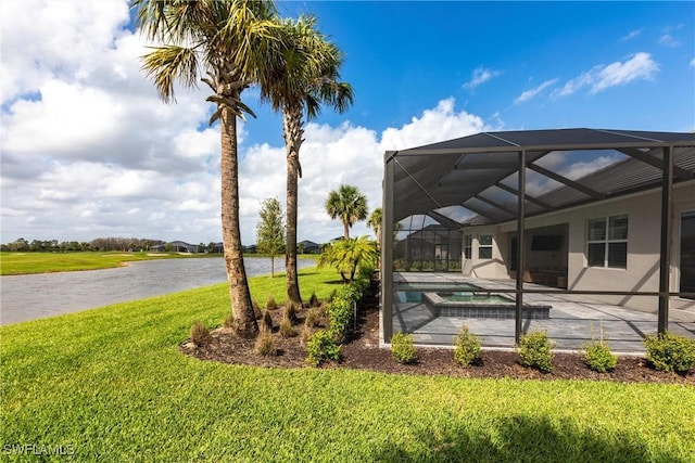 exterior space featuring glass enclosure, a pool with connected hot tub, a patio area, and a lawn