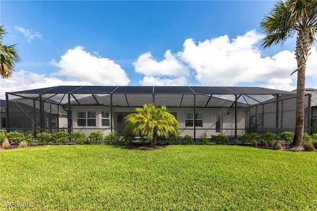 rear view of property featuring a yard and a lanai