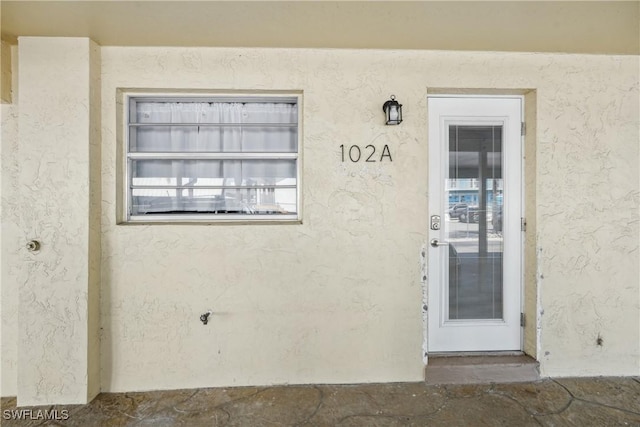 doorway to property with stucco siding