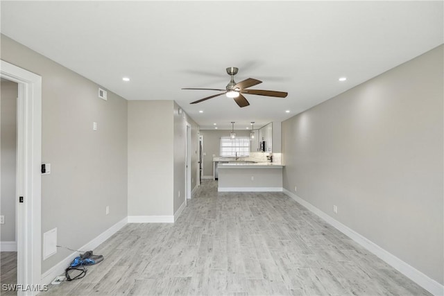 unfurnished living room with recessed lighting, ceiling fan, light wood-style flooring, and baseboards