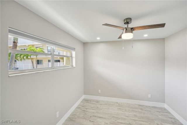 empty room with recessed lighting, wood finished floors, a ceiling fan, and baseboards