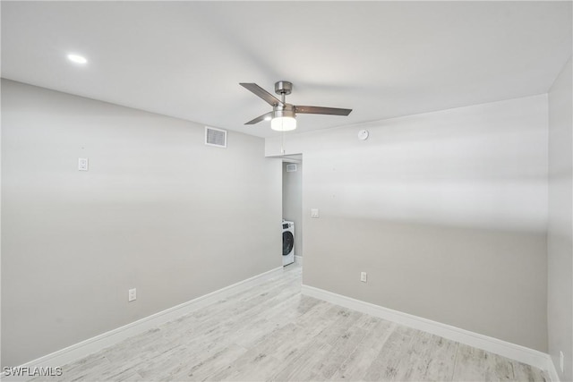 unfurnished room featuring washer / dryer, visible vents, baseboards, ceiling fan, and wood finished floors