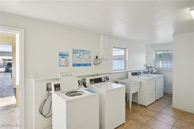 common laundry area with light tile patterned flooring and washing machine and clothes dryer