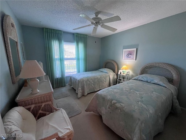 bedroom with carpet, ceiling fan, and a textured ceiling