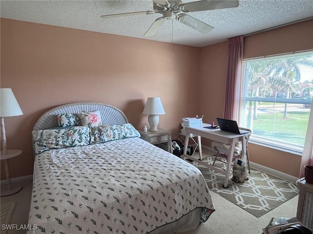 carpeted bedroom featuring ceiling fan, baseboards, and a textured ceiling