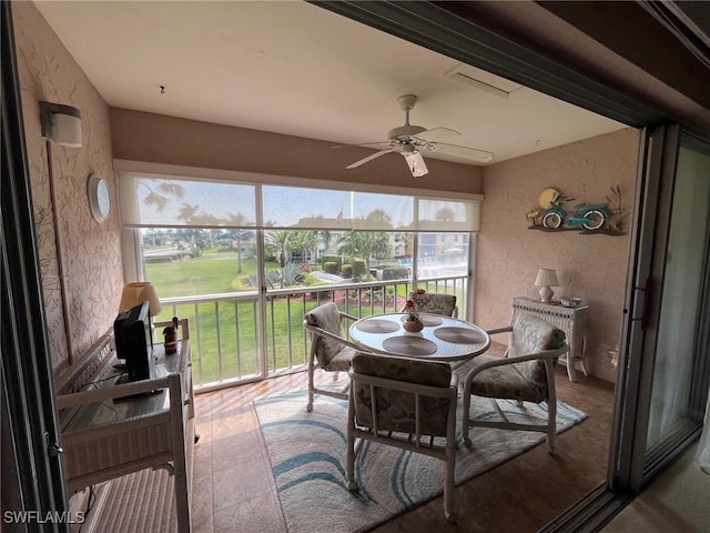 sunroom / solarium with a ceiling fan