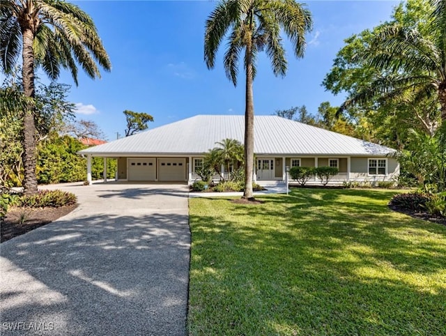 view of front of house with a garage, concrete driveway, a front lawn, and metal roof