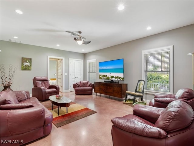 living room featuring baseboards, visible vents, a ceiling fan, finished concrete floors, and recessed lighting