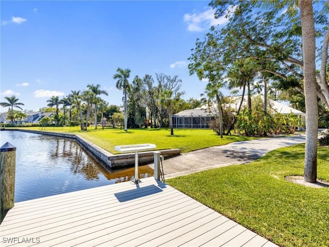 view of dock featuring a water view and a yard