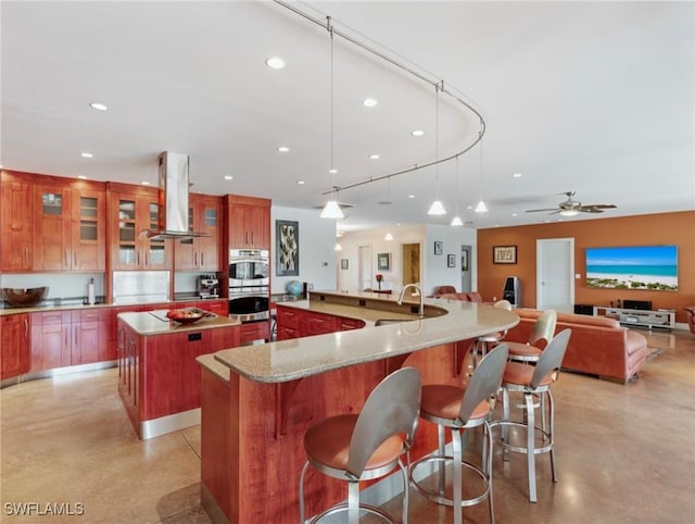 kitchen with a spacious island, stainless steel double oven, island range hood, and recessed lighting